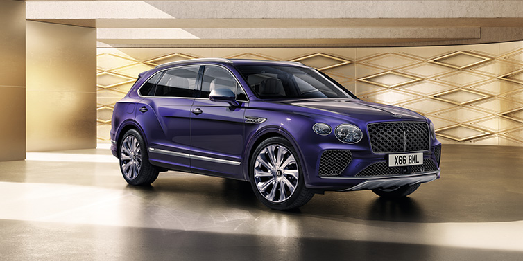 Bentley Zurich Bentley Bentayga Extended Wheelbase Mulliner SUV front three quarter in Tanzanite Purple paint with a gold patterned background