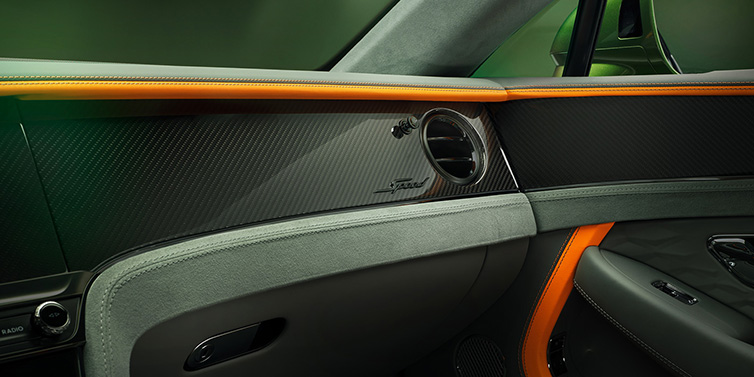 Bentley Zurich Bentley Continental GT Speed coupe front interior dash detail with high gloss carbon fibre veneer surrounded by Mandarin by Mulliner and Gravity Grey hides