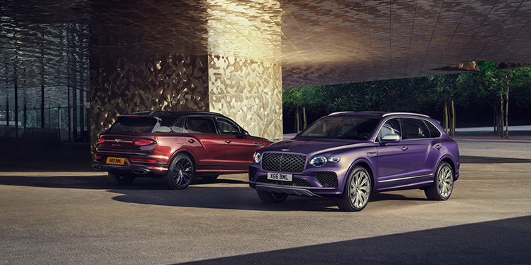 Bentley Zurich A duo of Bentley Bentayga Extended Wheelbase Mulliner SUVs parked in a city environment, with Tanzanite Purple and Cricket Ball red exterior paint