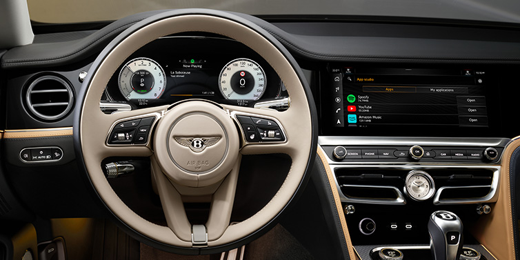 Bentley Zurich Bentley Flying Spur Mulliner sedan front interior detail of steering wheel and driver screens surrounded by Linen and Beluga black hides